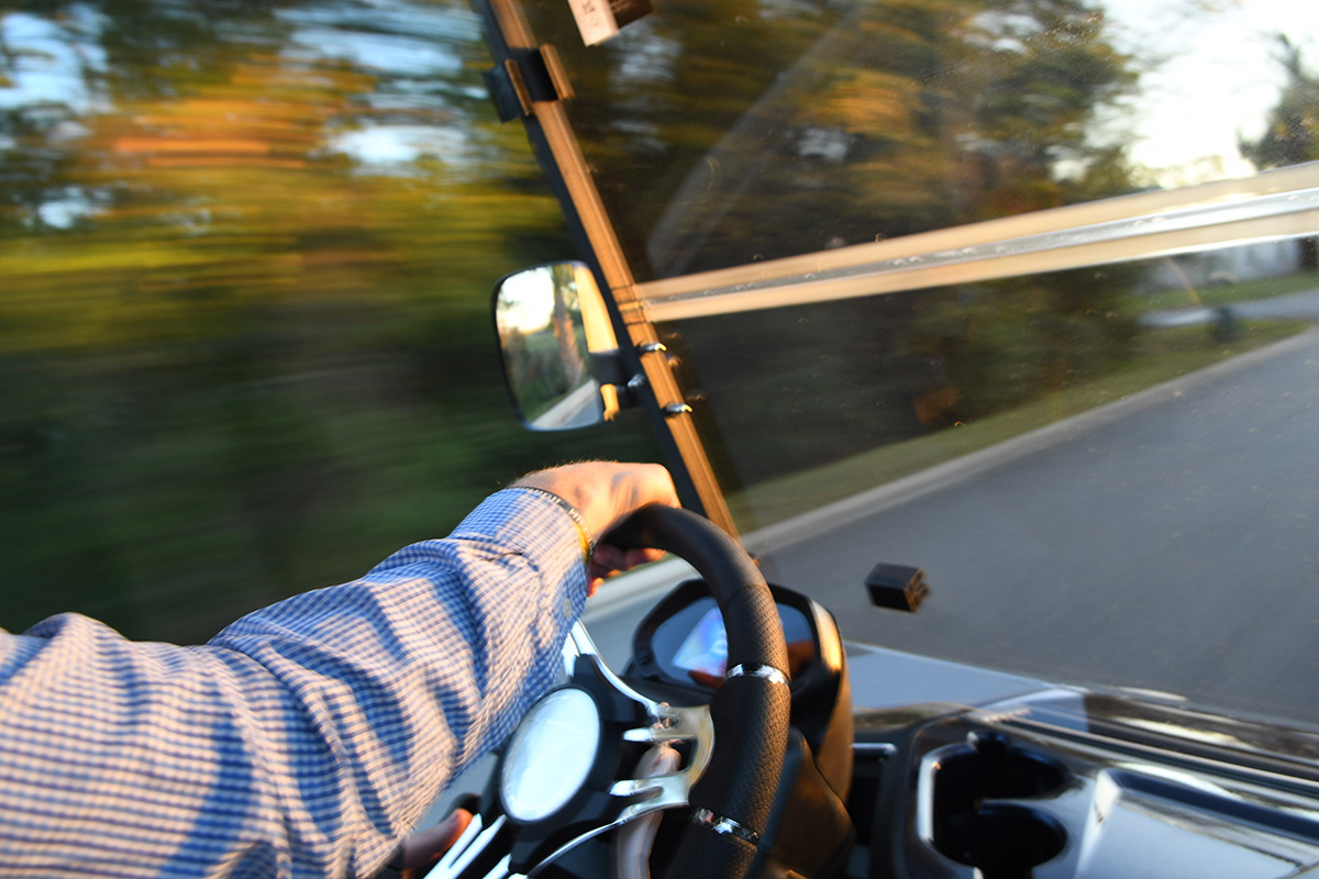 driver behind the wheel of a golf cart